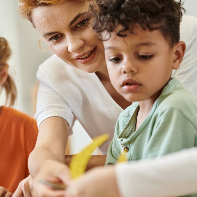 Kinder bekommen von einer Pädagogin etwas gezeigt